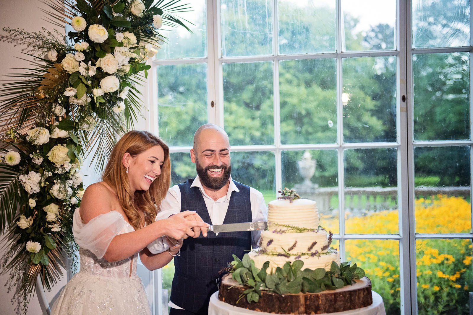 Margam Country Park (104 of 109) Candid photo of bride and groom cutting their wedding cake at Margam Country Park, taken by Blooming Photography.