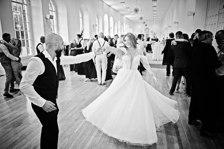 Candid B&W photo of bride and groom dancing at Margam Country Park, taken by Blooming Photography.
