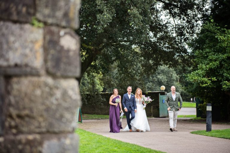 Bride walking with her father and bridesmaid as they arrive at Margam Country Park. Photographed by Blooming Photography