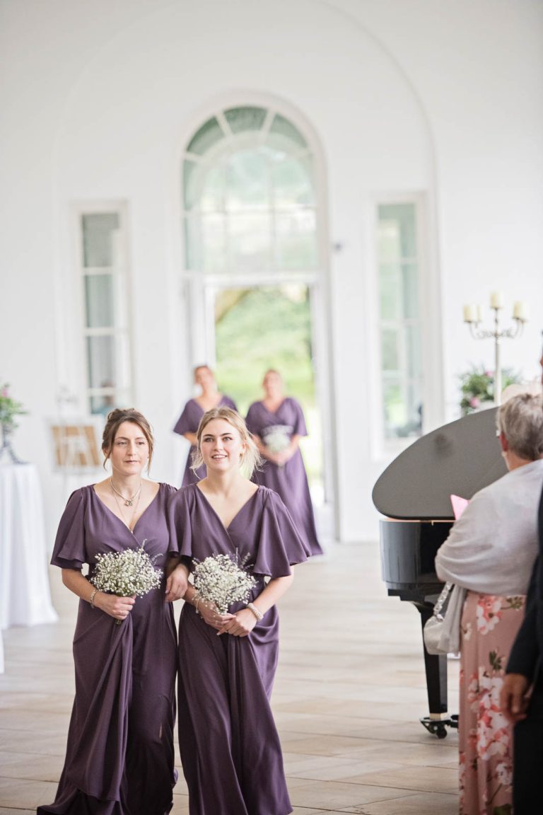 Elegant portrait photo of bridesmaids walking down the wedding isle at Margam Country Park. Photographed by Blooming Photography
