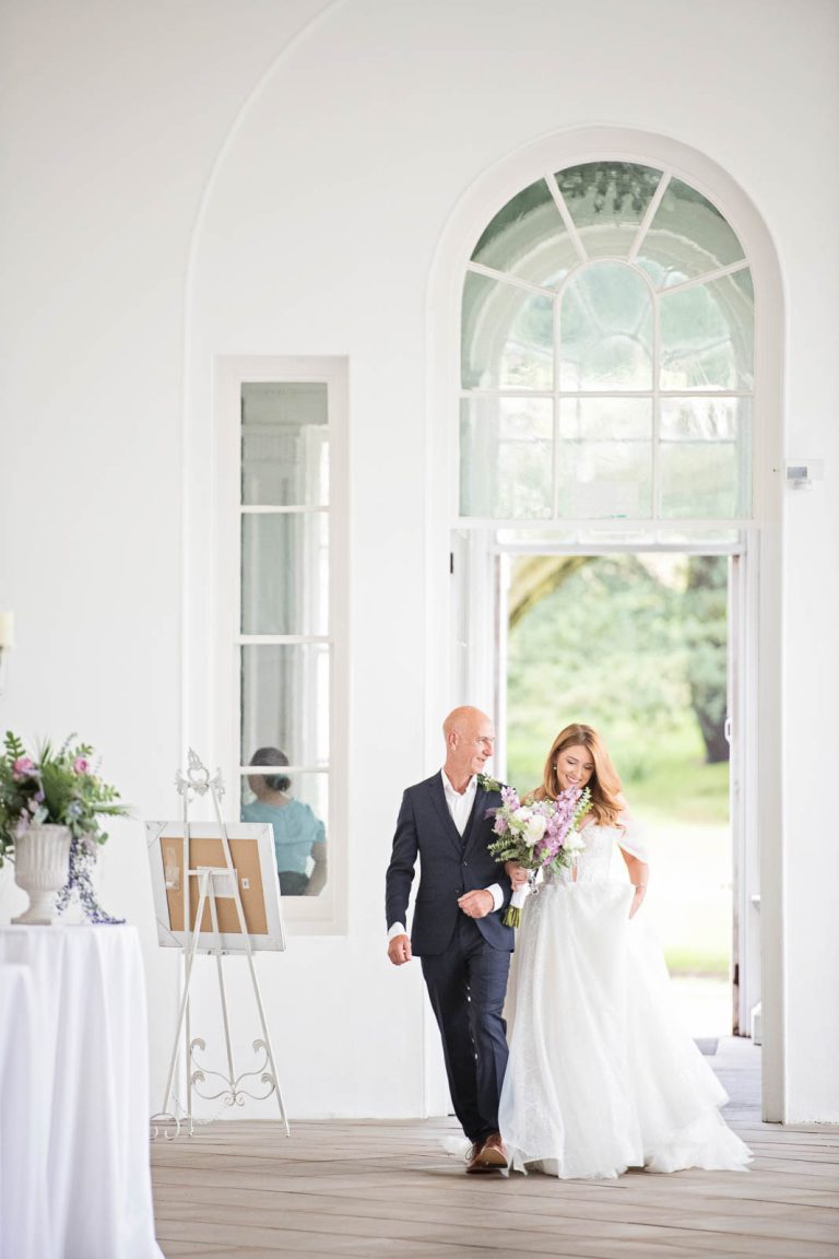 Elegant portrait candid photo of a bride and her dad walking down the wedding isle at Margam Country Park. Photographed by Blooming Photography