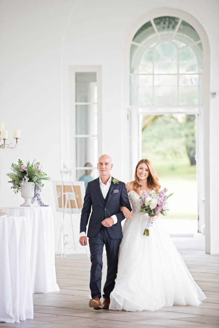 Elegant portrait photo of a bride and her dad walking down the wedding isle at Margam Country Park. Photographed by Blooming Photography