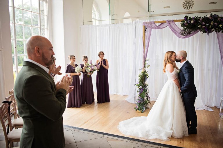 Natural photo of bride and groom kissing after being announced husband and wife. Photographed by Blooming Photography at a wedding at Margam Country Park.