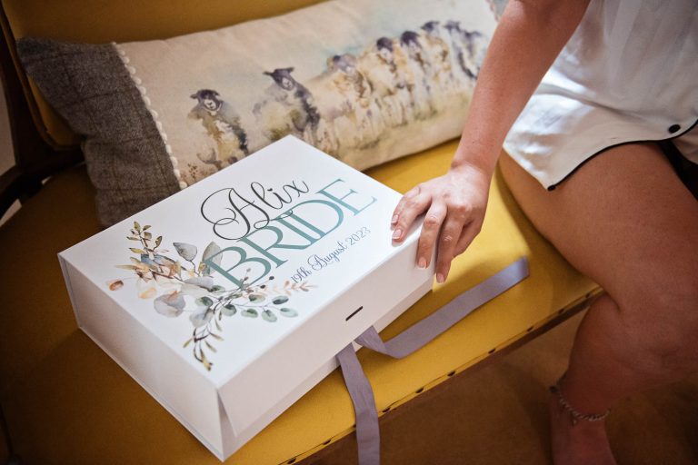 Bride looking at wedding details box by Cardiff wedding photographer, Blooming Photography