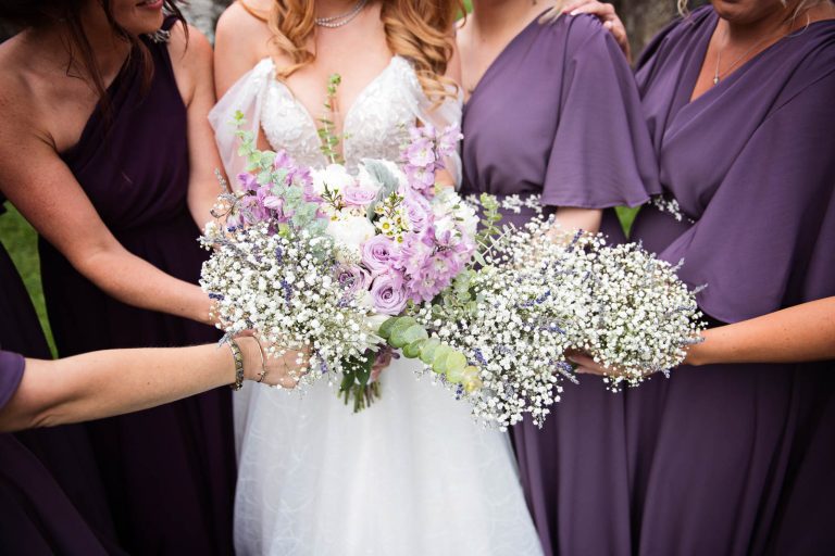 Bride and bridesmaids hold the wedding bouquets in one big bunch. Colourful. Photo taken at Margam Country Park by Blooming Photography.