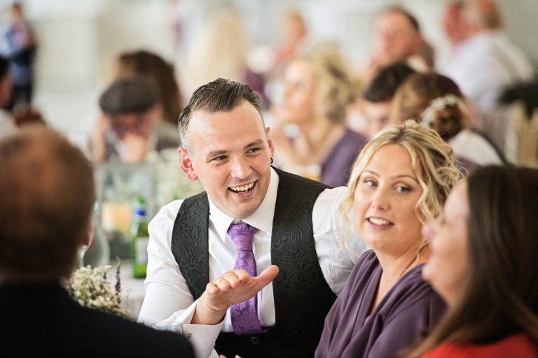 Candid image taken of the guests chatting and laughing at Margam Country Park, during the wedding breakfast by Blooming Photography.