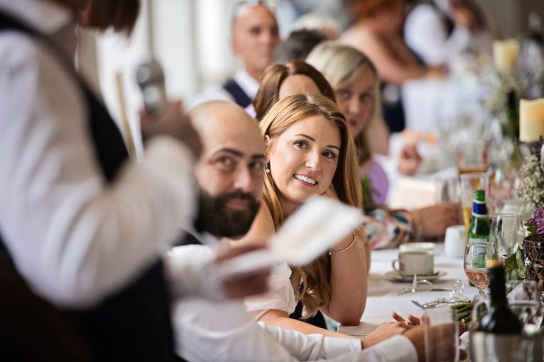 Candid image taken focusing on the bride at Margam Country Park, during the wedding speeches by Blooming Photography.