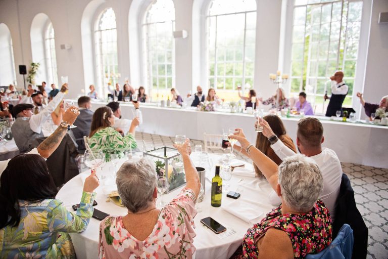 Candid colour wide view image taken at Margam Country Park, during the wedding speeches by Blooming Photography.