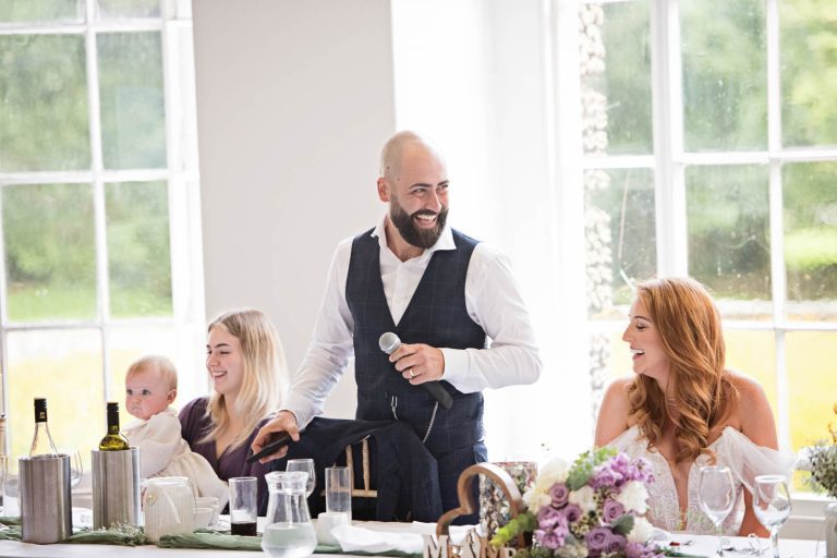 Candid image of the groom taken at Margam Country Park, during the wedding speeches by Blooming Photography.