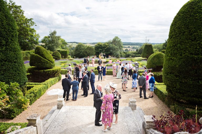 An overview of people chatting in the formal gardens at Danesfield House Hotel and spa. Timeless photograph. Photography by Ben Roberts Blooming Photography.