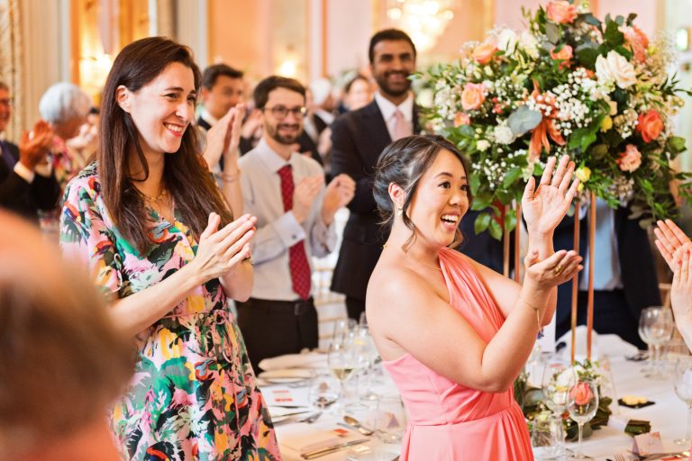 Guests clapping in a natural photo taken as the bride and groom (not seen in picture) enter Danesfield House Ballroom. Photograph by Ben Roberts, Blooming Photography.