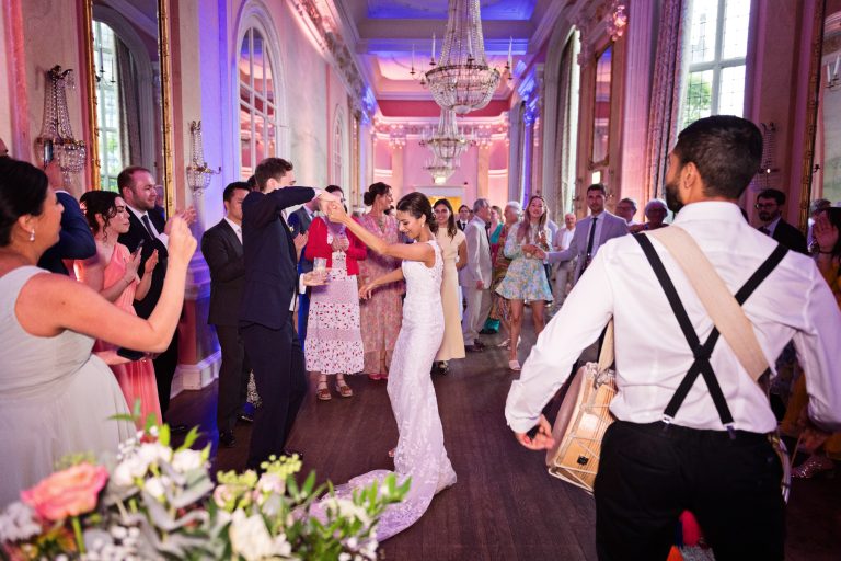 Bride and groom dance to the drumbeat of the Indian drummers. Photographed in the elegant Danesfield House Hotel and Spa Ballroom. Photograph by Ben Roberts, Blooming Photography.