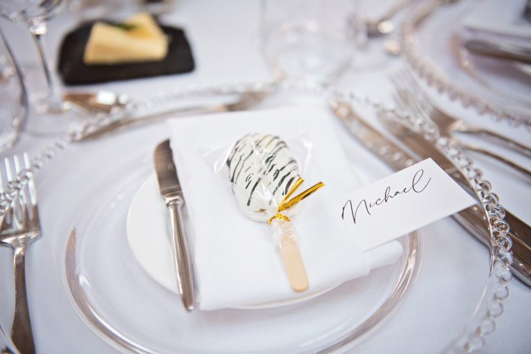 Wedding table layout. Elegant design and a wrapped lolly laid on a series of wedding plates. Photo taken at Blackwell Grange, Warwickshire, By Blooming Photography.