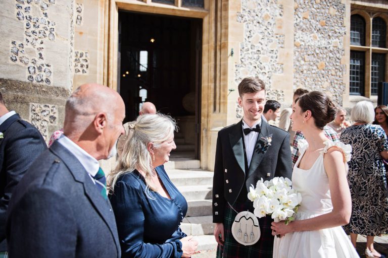 Wedding guests talking outside Winchester Registry office wedding. Photo by Blooming Photography