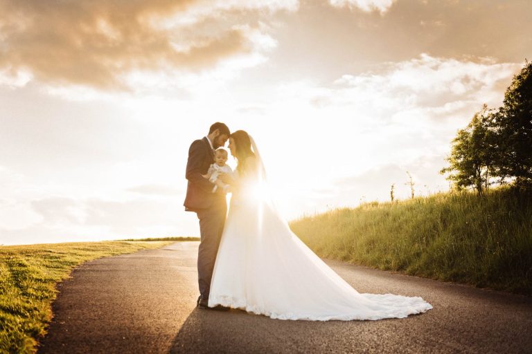 Kingscote Barn sunset of bride and groom and baby