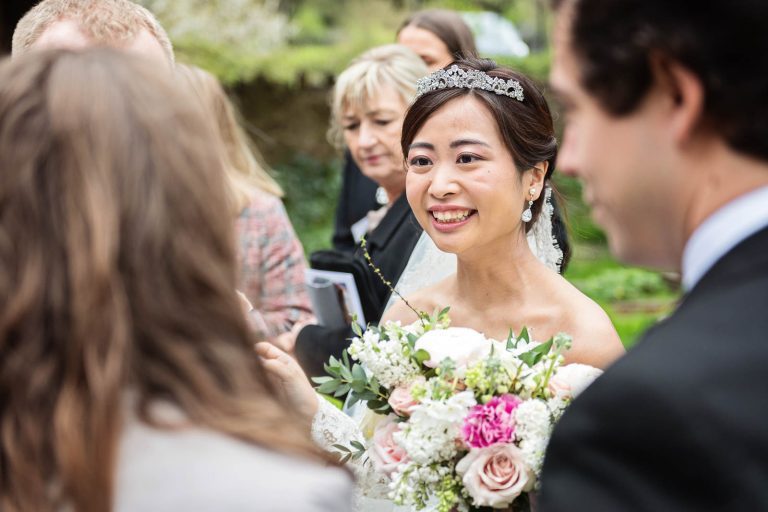 Candid photograph of bride talking to guests. Story telling photograph by Blooming Photography.