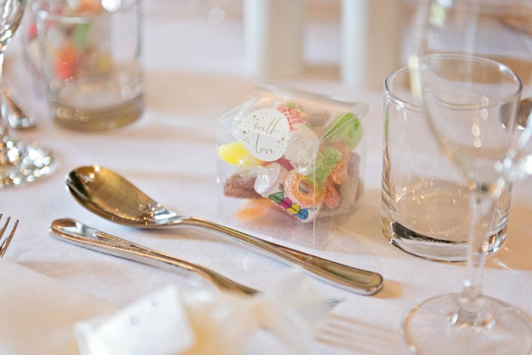 Wedding breakfast details - sweets, knife and fork and glasses.