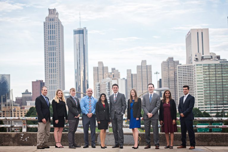 Team photograph with 10 colleagues standing in front of the dramatic Atlanta skyline.