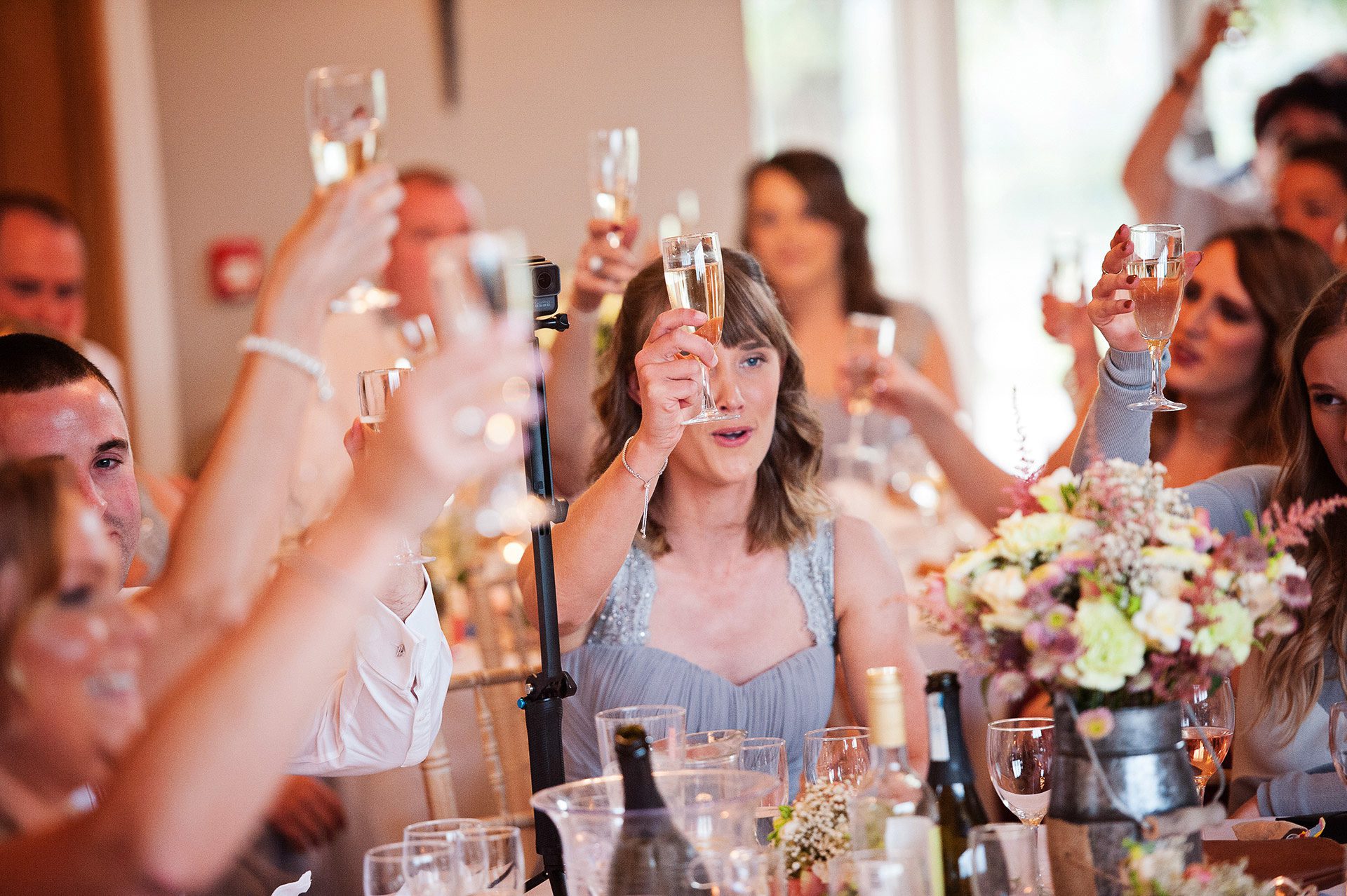 Storytelling photo of wedding party raising a glass for the end of speeches.